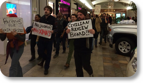Protestors carry anti-police violence signs through Oxmoor Mall PHOTO